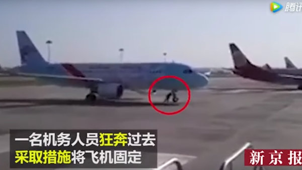 Entre-temps en Chine: un employé d'aéroport arrête un avion à mains nues - Sputnik Afrique