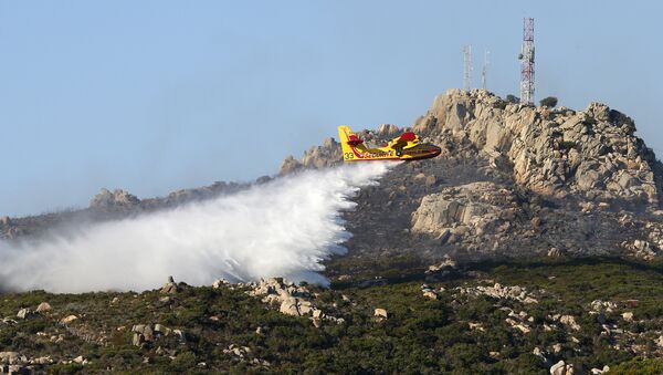 A fire fighting Canadair aircraft drops water on a fire close near Bonifacio, in southern Corsica, on July 17, 2017 on the French Mediterranean island of Corsica, burning some 200 hectors of land. - Sputnik Afrique
