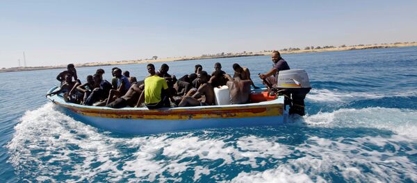 Migrants ride in a boat after they were rescued by Libyan coastguard off the coast of Gharaboli, east of Tripoli, Libya July 8, 2017 - Sputnik Afrique