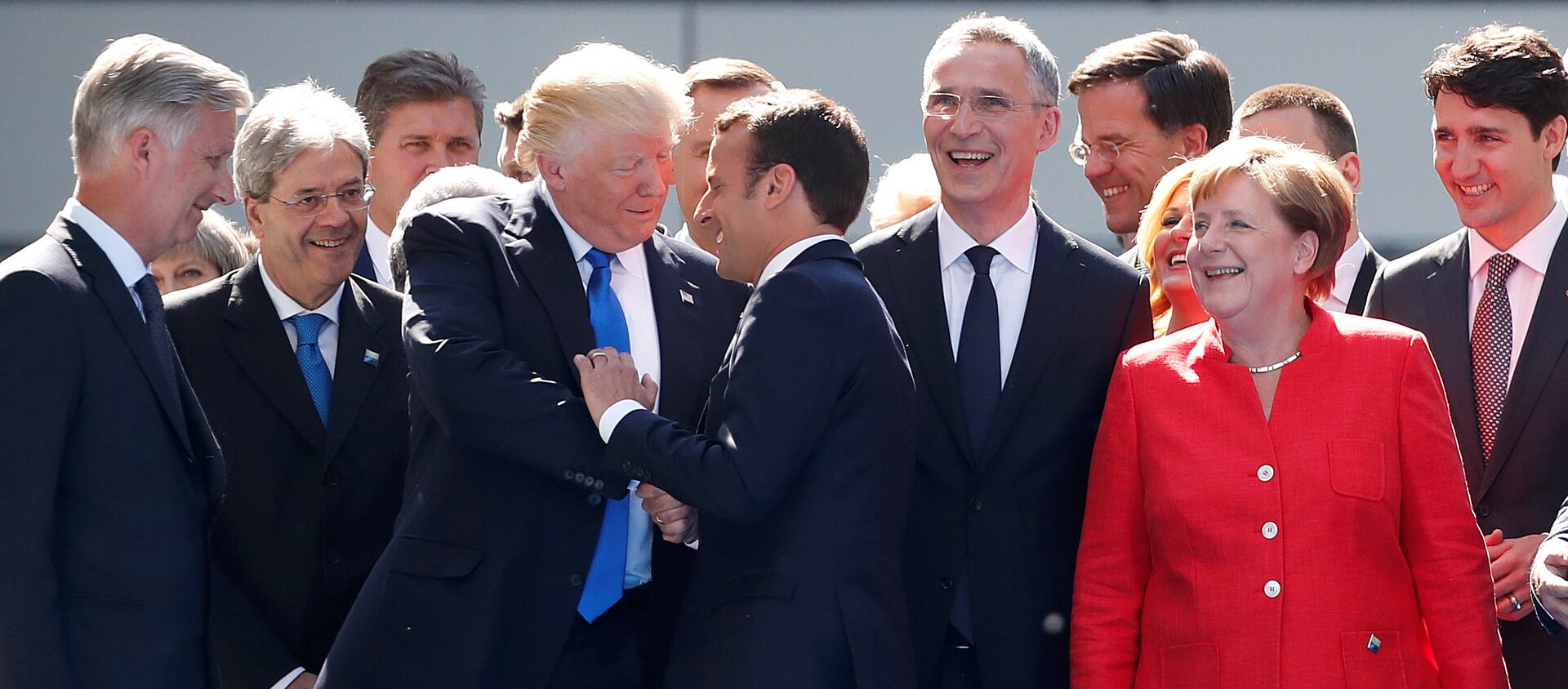 From L-R, Belgium's King Philipe, Italian Prime Minister Paolo Gentiloni, U.S. President Donald Trump who shakes hands with French President Emmanuel Macron, NATO Secretary General Jens Stoltenberg, Dutch Prime Minster Mark Rutte, German Chancellor Angela Merkel, and Canada's Prime Minister Justin Trudeau gather with NATO member leaders to pose for a family picture before the start of their summit in Brussels, Belgium, May 25, 2017 - Sputnik Afrique, 1920, 29.11.2019
