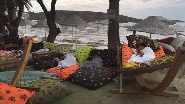 A man sleeps on the beachfront after spending the night outdoors following an earthquake in Bitez, a resort town about 6 kilometers (4 miles) west of Bodrum, Turkey, Friday, July 21, 2017 - Sputnik Afrique