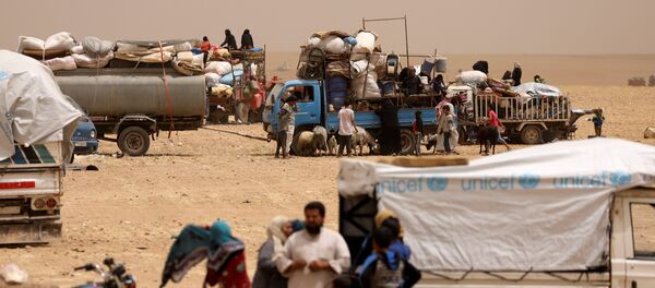 Internally displaced people who fled Raqqa city gather near vehicles carrying their belongings in a camp near Ain Issa, Raqqa Governorate, Syria May 19, 2017 - Sputnik Afrique