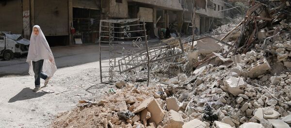 A girl walks past the rubble of a destroyed building down a street in the rebel-held Syrian town of Ayn Tarma, in the Ghouta area east of the capital Damascus on July 19, 2017. - Sputnik Afrique