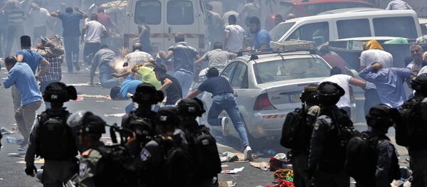 Palestinian worshippers run for cover from teargas, fired by Israeli forces, following prayers outside Jerusalem's Old City in front of the Al-Aqsa mosque compound after Israeli police barred men under 50 from entering the Old City for Friday Muslim prayers as tensions rose and protests erupted over new security measures at the highly sensitive holy site on July 21, 2017. - Sputnik Afrique