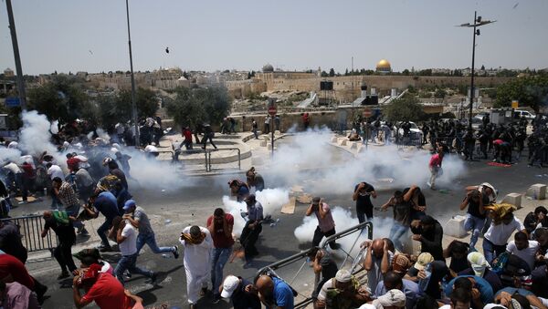 Palestinian worshippers run for cover from teargas, fired by Israeli forces, following prayers outside Jerusalem's Old City in front of the Al-Aqsa mosque compound after Israeli police barred men under 50 from entering the Old City for Friday Muslim prayers as tensions rose and protests erupted over new security measures at the highly sensitive holy site on July 21, 2017. - Sputnik Afrique