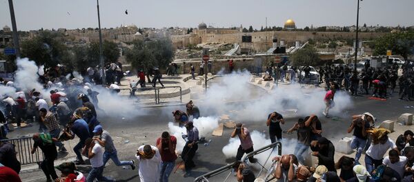 Palestinian worshippers run for cover from teargas, fired by Israeli forces, following prayers outside Jerusalem's Old City in front of the Al-Aqsa mosque compound after Israeli police barred men under 50 from entering the Old City for Friday Muslim prayers as tensions rose and protests erupted over new security measures at the highly sensitive holy site on July 21, 2017. - Sputnik Afrique