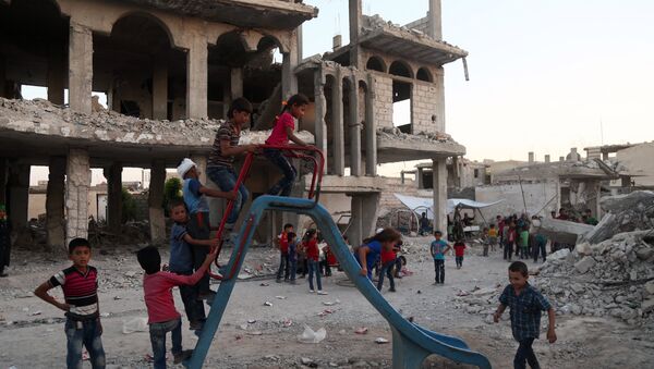 Syrian children, who fled their homes in Ghouta's al-Marj town, play amidst the debris of buildings in the town of al-Nashabiyah in the eastern Ghouta region, a rebel stronghold east of the capital Damascus on June 27, 2017. - Sputnik Afrique