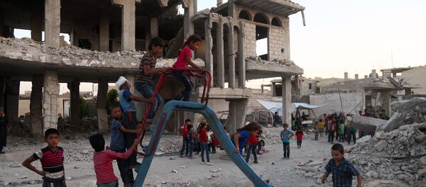 Syrian children, who fled their homes in Ghouta's al-Marj town, play amidst the debris of buildings in the town of al-Nashabiyah in the eastern Ghouta region, a rebel stronghold east of the capital Damascus on June 27, 2017. - Sputnik Afrique