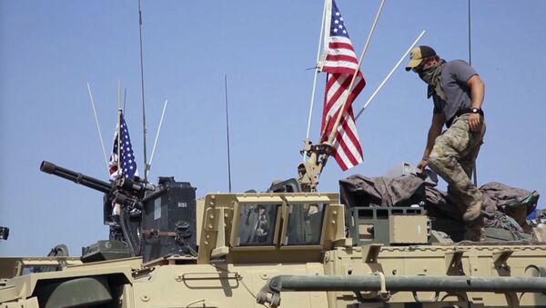 This Saturday, April. 29, 2017 still taken from video, shows an American soldier standing on an armored vehicle in the northern village of Darbasiyah, Syria - Sputnik Afrique