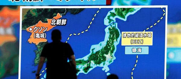 Men walk past a street monitor showing news of North Korea's intercontinental ballistic missile test in Tokyo, Japan. (File) - Sputnik Afrique