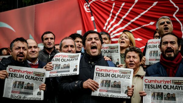 Protesters hold copies of the latest edition of the the Turkish daily newspaper Cumhuriyet as they shout slogans during a demonstration outside the newspaper's headquarters in Istanbul on November 1,2016 a day after its editor in chief was detained by police. - Sputnik Afrique