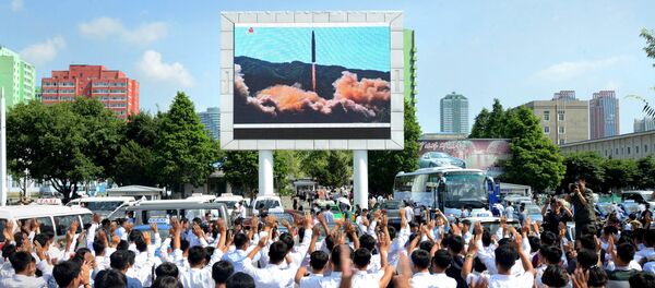 People watch a huge screen showing the test launch of intercontinental ballistic missile Hwasong-14 in this undated photo released by North Korea's Korean Central News Agency (KCNA), July 5, 2017 - Sputnik Afrique