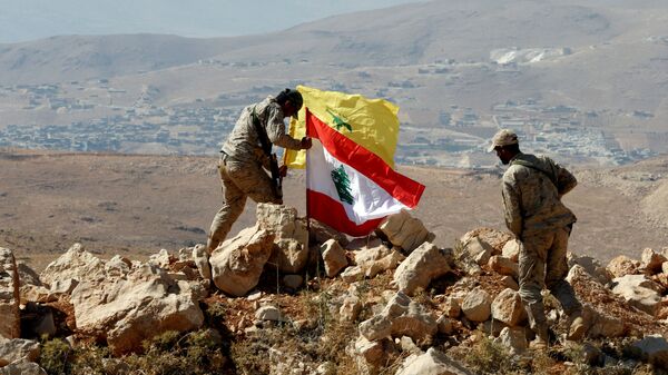 Des combattants du Hezbollah mettent des drapeaux libanais et du Hezbollah à Juroud Arsal, à la frontière syro-libanaise, le 25 juillet 2017. - Sputnik Afrique