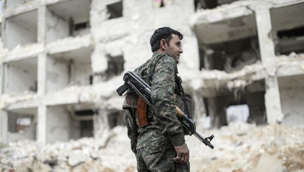 A Kurdish fighter walks through the wreckage of a building in the center of the Syrian town of Kobane, also known as Ain al-Arab, on January 28, 2015. - Sputnik Afrique