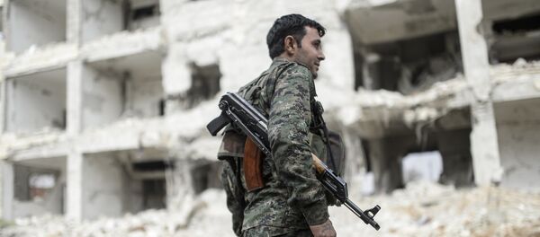 A Kurdish fighter walks through the wreckage of a building in the center of the Syrian town of Kobane, also known as Ain al-Arab, on January 28, 2015. A Kurdish fighter walks through the wreckage of a building in the center of the Syrian town of Kobane, also known as Ain al-Arab, on January 28, 2015. - Sputnik Afrique