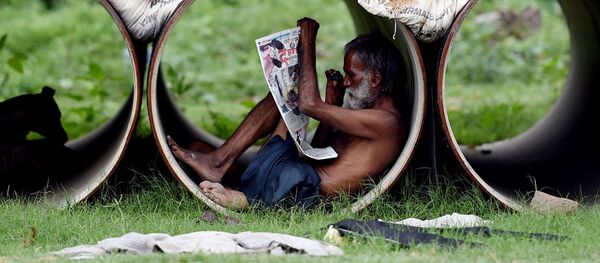 Индиец читает газету внутри трубы в Нью-Дели - Sputnik Afrique