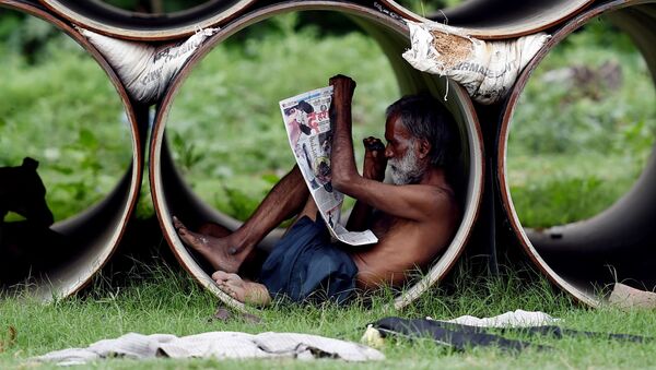 Индиец читает газету внутри трубы в Нью-Дели - Sputnik Afrique
