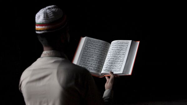 Un musulman pakistanais lisant le Coran (photo d'archives) - Sputnik Afrique