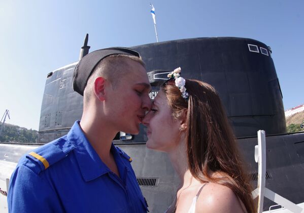 Un militaire avec une jeune fille lors de la réception du sous-marin diesel Krasnodar à Sébastopol - Sputnik Afrique