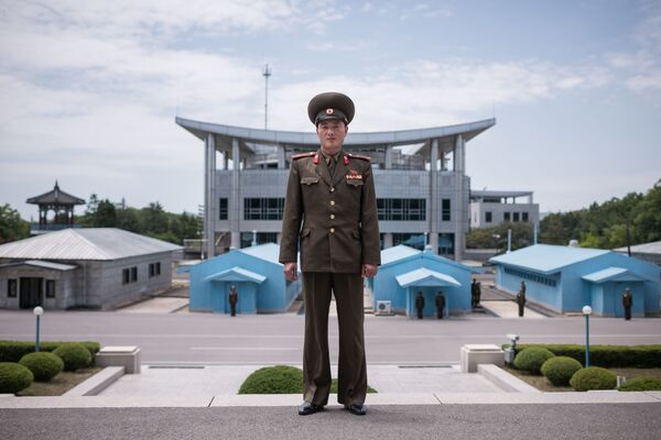 Un militaire de l’Armée populaire de Corée devant la ligne de démarcation dans la zone démilitarisée entre la Corée du Nord et la Corée du Sud - Sputnik Afrique