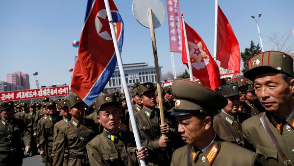 North Korean soldiers carry flags as they visit the newly constructed residential complex after its opening ceremony in Ryomyong street in Pyongyang, North Korea April 13, 2017 - Sputnik Afrique
