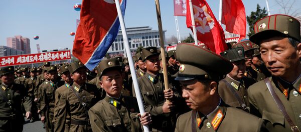 North Korean soldiers carry flags as they visit the newly constructed residential complex after its opening ceremony in Ryomyong street in Pyongyang, North Korea April 13, 2017 - Sputnik Afrique