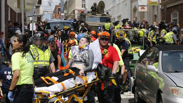 Rescue personnel help injured people after a car ran into a large group of protesters after a white nationalist rally in Charlottesville, Va., Saturday, Aug. 12, 2017. - Sputnik Afrique