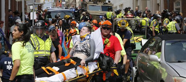 Rescue personnel help injured people after a car ran into a large group of protesters after a white nationalist rally in Charlottesville, Va., Saturday, Aug. 12, 2017. - Sputnik Afrique