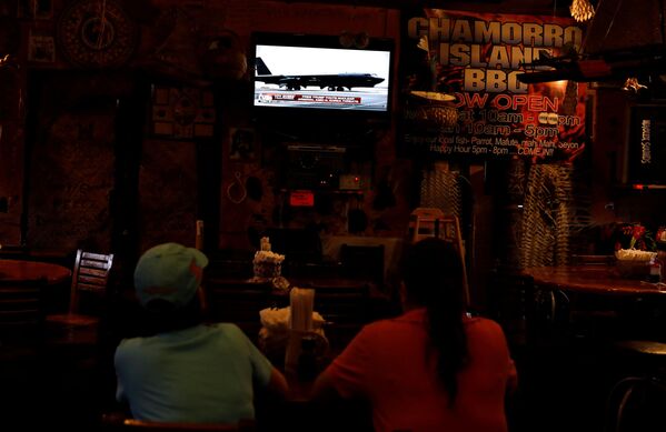 Dans un restaurant de l’île de Guam (États-Unis), des habitants regardent un journal télévisé consacré à la crise nord-coréenne. - Sputnik Afrique