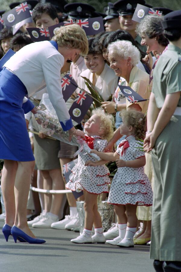 Deux petites sœurs jumelles offrent des fleurs à la princesse Diana lors du dernier jour de sa tournée en Asie, Hongkong, 1989 - Sputnik Afrique