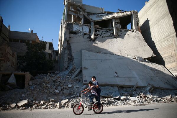 Des gamins font du vélo près des immeubles en ruine à Damas, en Syrie - Sputnik Afrique