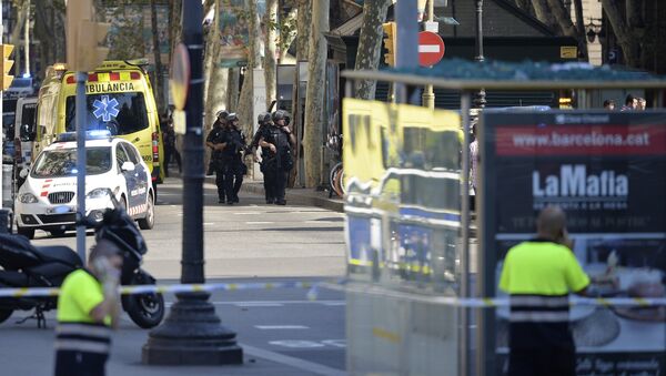 Armed policemen arrive in a cordoned off area after a van ploughed into the crowd, injuring several persons on the Rambla in Barcelona on August 17, 2017 - Sputnik Afrique