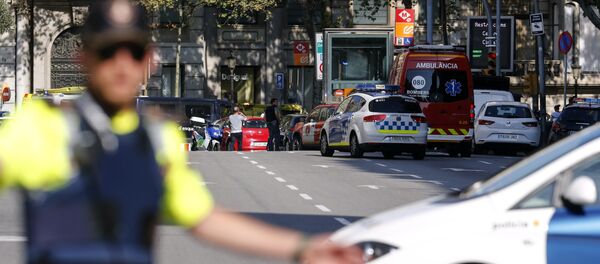 A policemen stand as he blocks the street to a cordoned off area after a van ploughed into the crowd, injuring several persons on the Rambla in Barcelona on August 17, 2017 - Sputnik Afrique