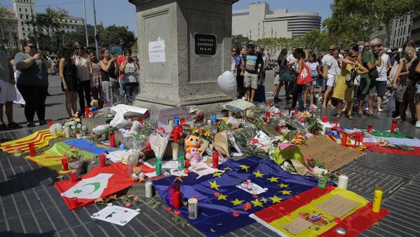 People look at flags, messages and candles placed after van attack that killed at least 13 in central Barcelona, Spain, Friday, Aug. 18, 2017. - Sputnik Afrique