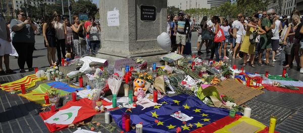 People look at flags, messages and candles placed after van attack that killed at least 13 in central Barcelona, Spain, Friday, Aug. 18, 2017. - Sputnik Afrique