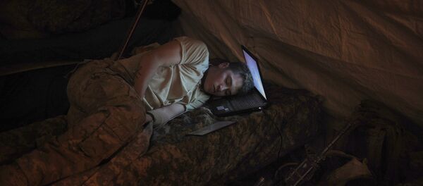 US infantryman Private Freymond Tyler of Delta Company, 2-87 Infantry Battalion, 3rd Brigade Combat Team, sleeps on his laptop next to his gun in the Delta Company barracks at combat outpost Makuan in Kandahar province in southern Afghanistan on August 13, 2011 - Sputnik Afrique