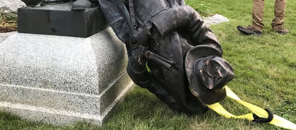 A Sheriff's deputy stands near the toppled statue of a Confederate soldier in front of the old Durham County Courthouse in Durham, North Carolina, U.S. August 14, 2017. - Sputnik Afrique