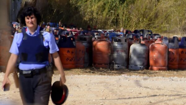 Eine Polizistin mit Gasflaschen im Hintergrund in Alcanar - Sputnik Afrique