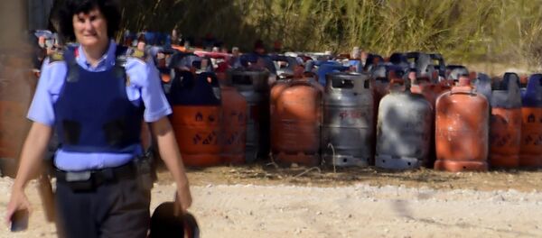 Eine Polizistin mit Gasflaschen im Hintergrund in Alcanar - Sputnik Afrique