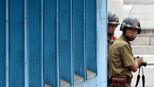 North Korean soldiers watch the south side as the United Nations Command officials visit after a commemorative ceremony for the 64th anniversary of the Korean armistice at the truce village of Panmunjom in the Demilitarized Zone (DMZ) dividing the two Koreas July 27, 2017. - Sputnik Afrique