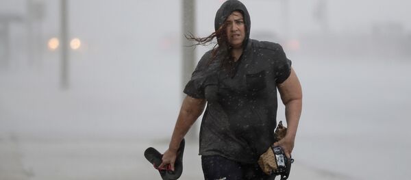 Hillary Lebeb walks along the seawall in Galveston, Texas as Hurricane Harvey intensifies in the Gulf of Mexico Friday, Aug. 25, 2017. - Sputnik Afrique