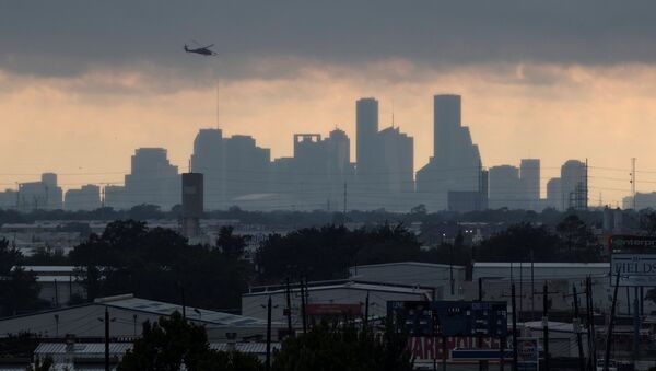 A helicopter hovers above the Houston skyline as sunlight breaks through storm clouds from Tropical Storm Harvey in Texas, U.S. - Sputnik Afrique