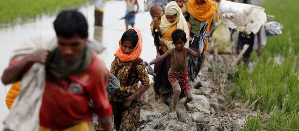 Rohingya refugees walk on the muddy path after crossing the Bangladesh-Myanmar border in Teknaf, Bangladesh, September 3, 2017. REUTERS/Mohammad Ponir Hossain - Sputnik Afrique