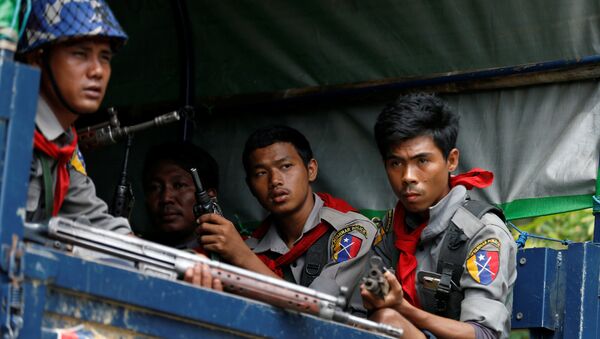 Myanmar police officers sit in a truck while patroling a road in Maungdaw in Myanmar - Sputnik Afrique
