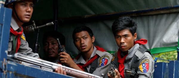 Myanmar police officers sit in a truck while patroling a road in Maungdaw in Myanmar - Sputnik Afrique