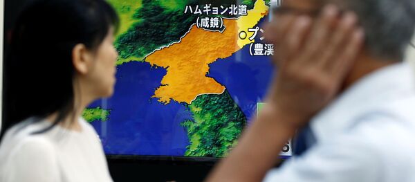 People walk past a street monitor showing a news report about North Korea's nuclear test, in Tokyo, Japan, September 3, 2017 - Sputnik Afrique