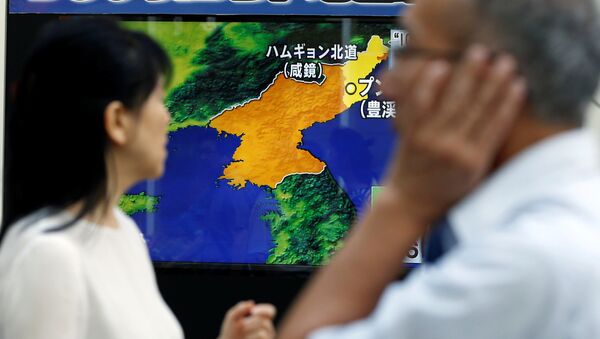 People walk past a street monitor showing a news report about North Korea's nuclear test, in Tokyo, Japan, September 3, 2017 - Sputnik Afrique