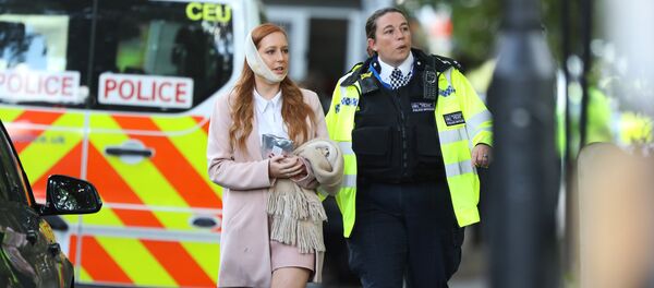 An injured woman is led away after an incident at Parsons Green underground station in London, Britain, September 15, 2017 - Sputnik Afrique