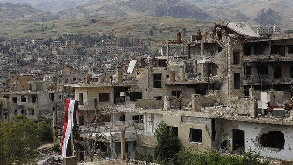 In this May 18, 2017, photo, a Syrian National flag hangs out of a damaged building at the mountain resort town of Zabadani in the Damascus countryside, Syria. - Sputnik Afrique