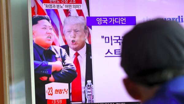 A man watches a television news programme showing US President Donald Trump (C) and North Korean leader Kim Jong-Un (L) at a railway station in Seoul on August 9, 2017 - Sputnik Afrique